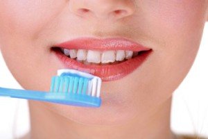 Beautiful young woman with toothbrush close-up